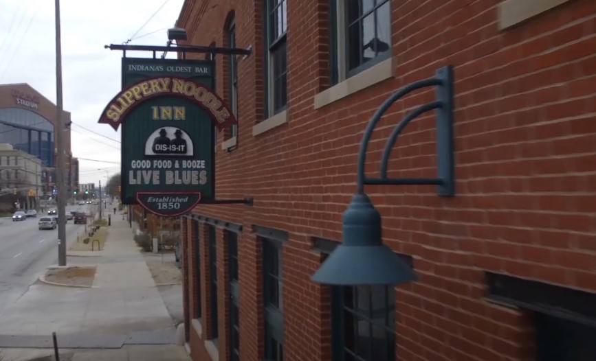 Slippery Noodle Inn sign hanging on the building's brick wall