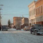 Vintage cars on a snowy street in a historic Indiana town, used as a filming location for Hollywood movies