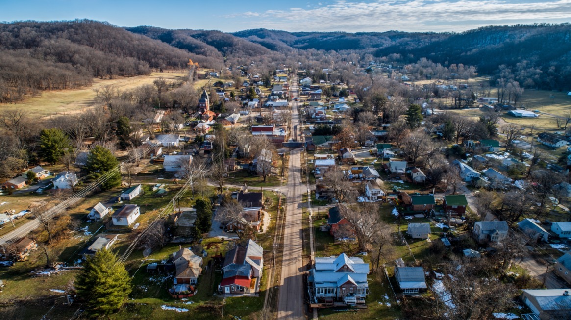 Aerial view of a small town in Brown County, Indiana, surrounded by rolling hills and seasonal landscapes