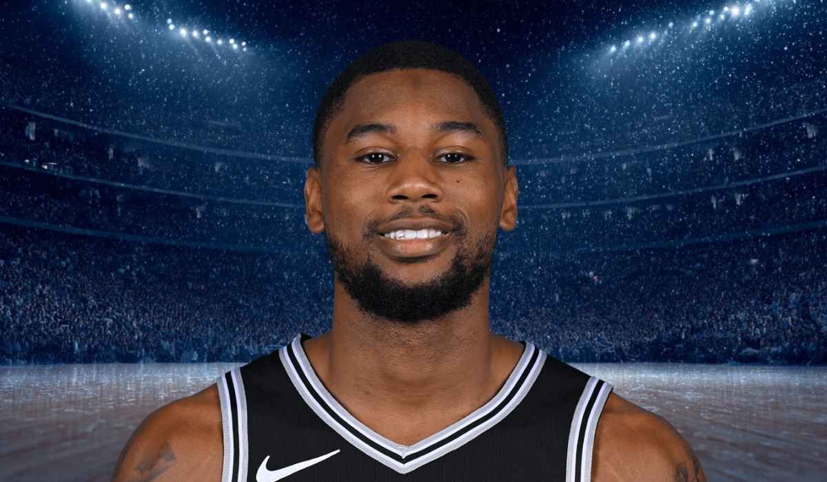 Basketball player in a black jersey smiling on the court