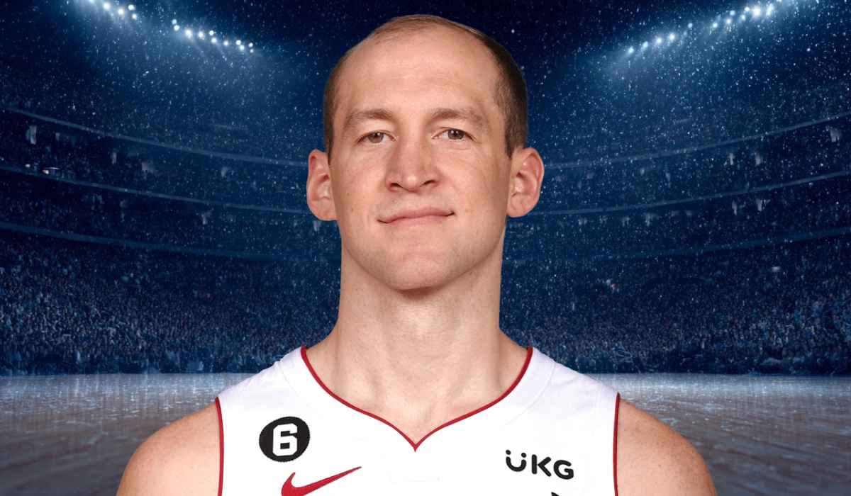 Basketball player in a white jersey standing on the court with a focused look