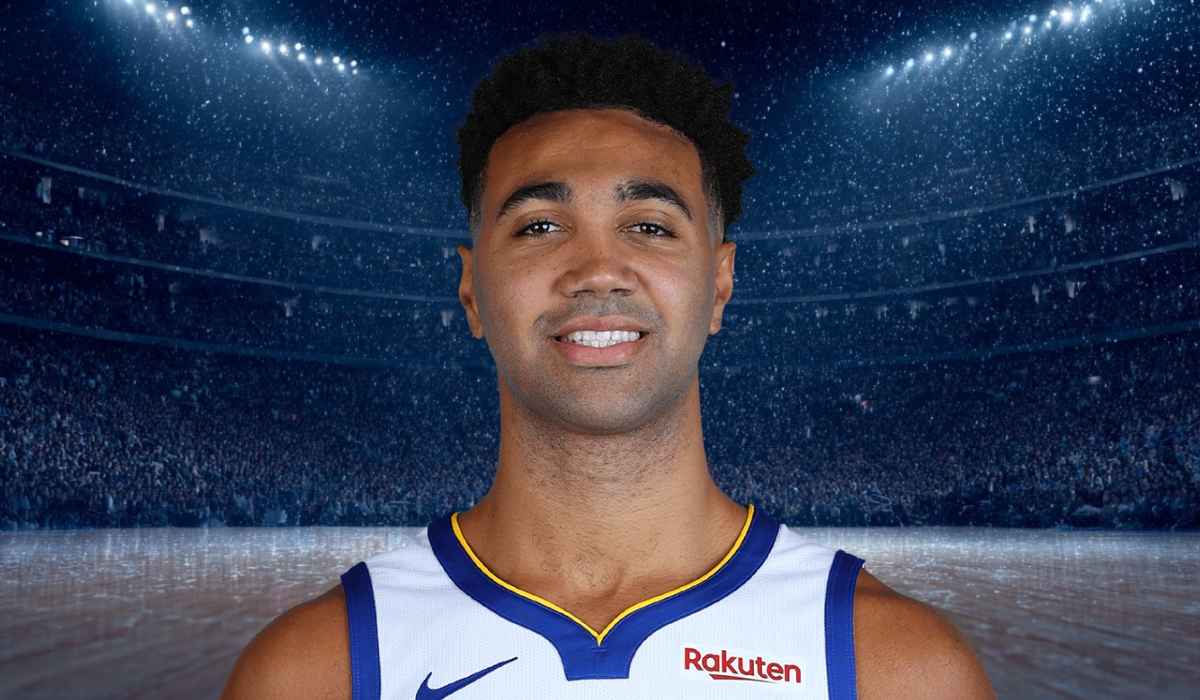 Basketball player smiling in a crowded arena under bright lights