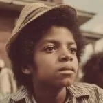 Portrait of a young boy outdoors in a 1960s neighborhood wearing a hat