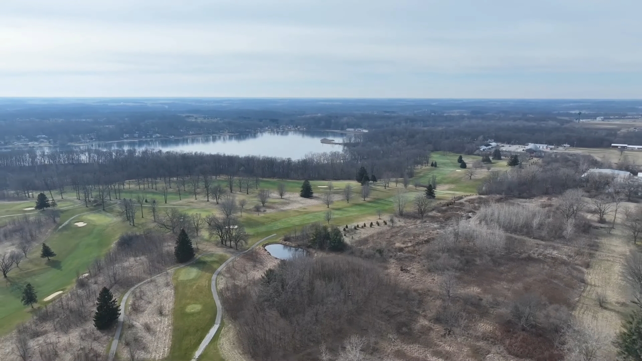 Aerial view of Angola with open land, golf greens, and a lake in the distance