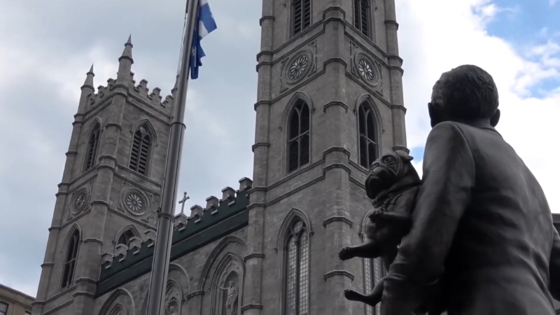 Statue in front of a church with twin towers in South Bend Indiana