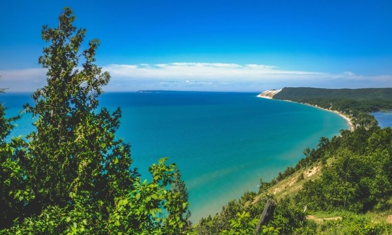 Expansive view of a turquoise bay with a curving coastline under a clear blue sky