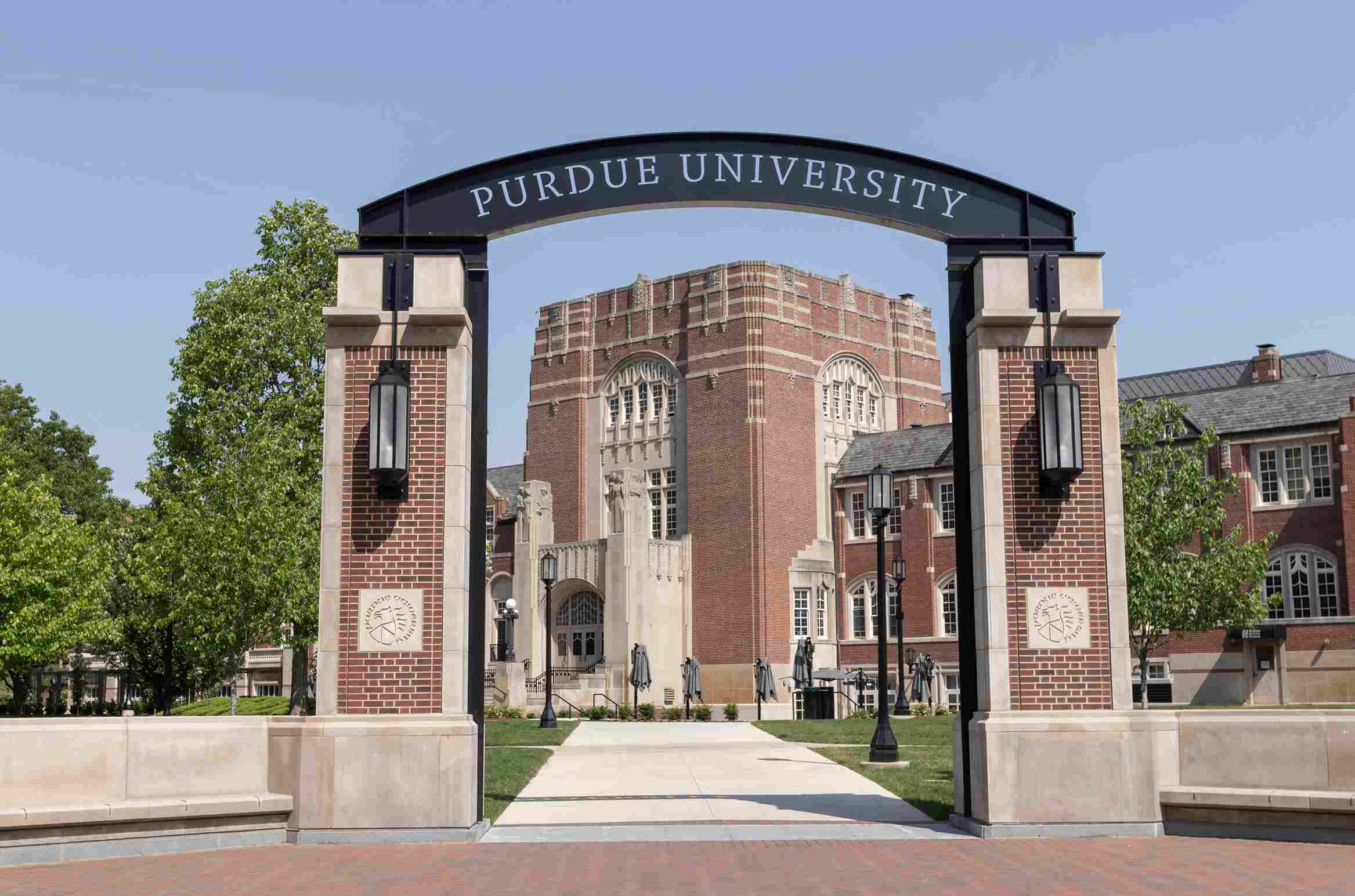 Archway entrance with Purdue University sign and campus building in the background