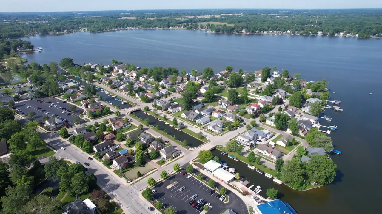 Aerial view of Winona Lake with homes, docks, and calm water along the shoreline