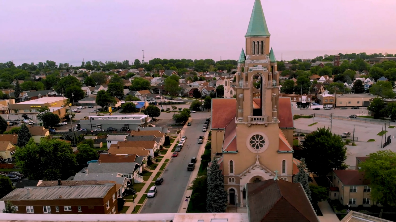 A church tower rises above Hammond’s residential streets at sunset