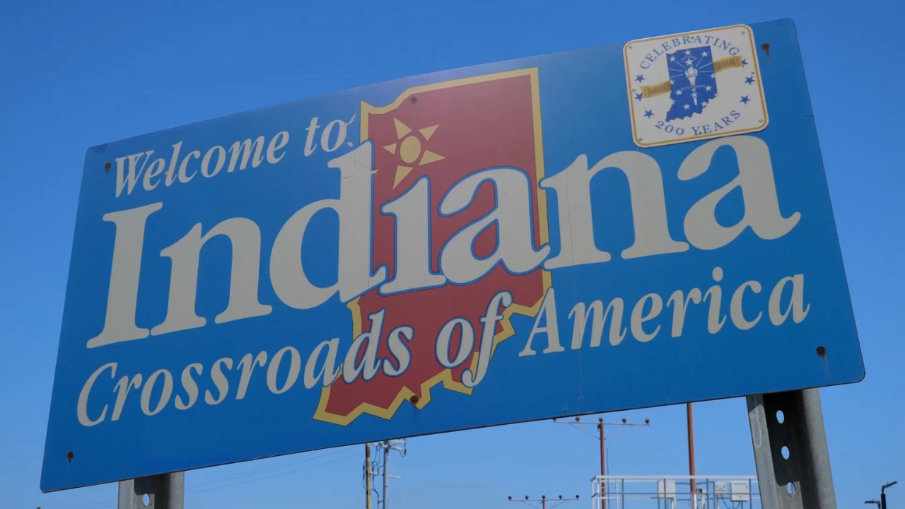 Welcome to Indiana road sign against a clear blue sky