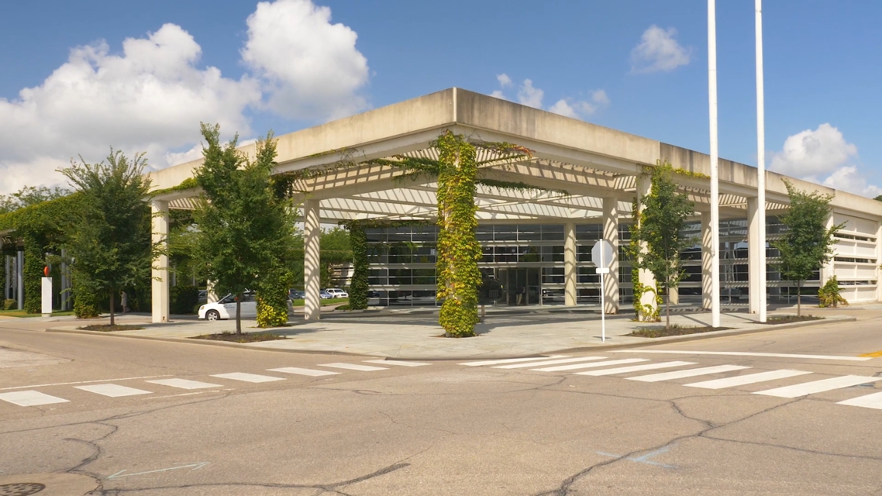 Modern civic hall in Columbus, Indiana, with ivy-covered columns beside a crosswalk