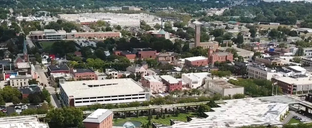 Aerial view of downtown Columbus, Indiana, with modern buildings, church towers, streets, and trees