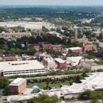 Aerial view of downtown Columbus, Indiana, with modern buildings, church towers, streets, and trees