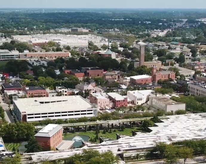 Aerial view of downtown Columbus, Indiana, with modern buildings, church towers, streets, and trees
