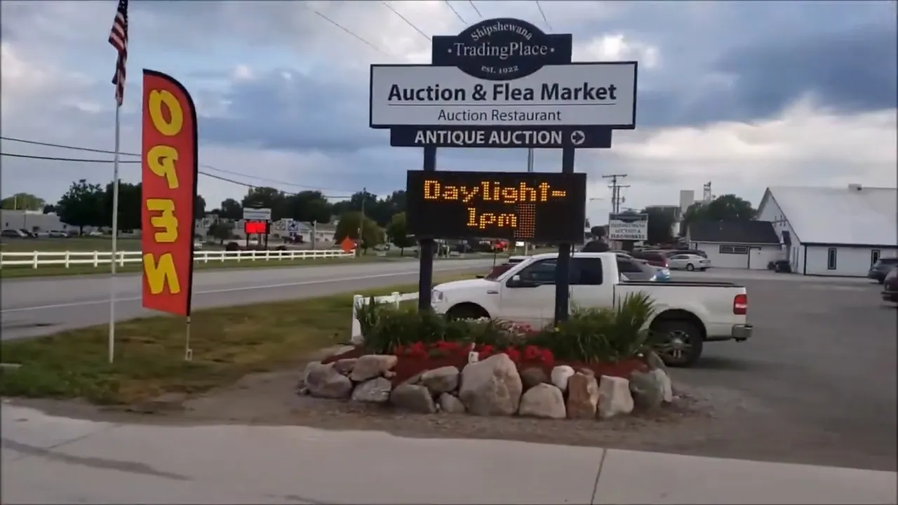 Shipshewana Flea Market and Auction sign stands beside the roadside entrance
