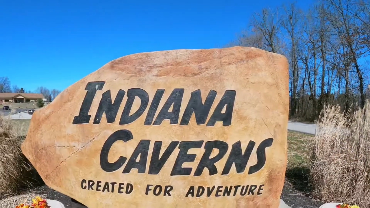Indiana Caverns entrance sign along a roadside on a clear day