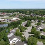 Aerial view of Carmel homes, tree-lined streets, shops, and green space