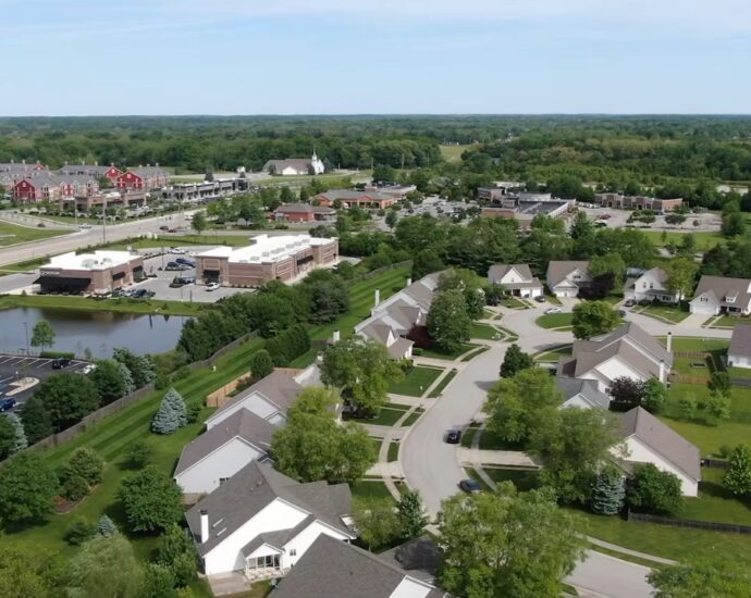 Aerial view of Carmel homes, tree-lined streets, shops, and green space