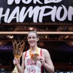 Caitlin Clark holds the championship trophy and medal after the final.