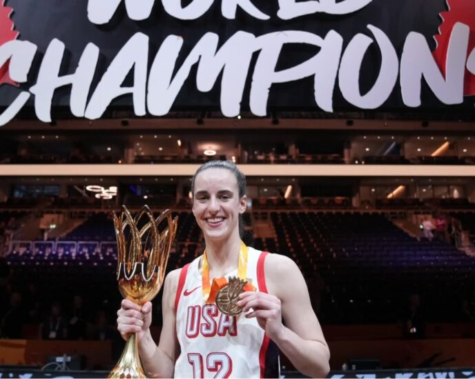 Caitlin Clark holds the championship trophy and medal after the final.